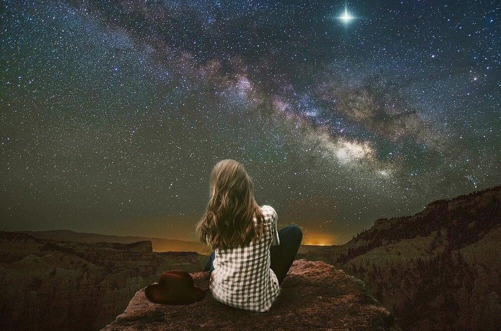 Girl looking at the stars as she dreams about what could be possible for her